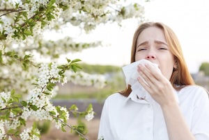 Woman sneezing due to pollen allergy